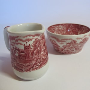 Puede incluir: Un juego vintage de jarra de crema y azucarero de cerámica con un patrón floral rojo y blanco.