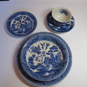 Puede incluir: Un juego de vajilla de porcelana azul y blanca con un tradicional diseño de sauce. El juego incluye un plato pequeño, un plato grande, un tazón y una taza de té y un platillo.