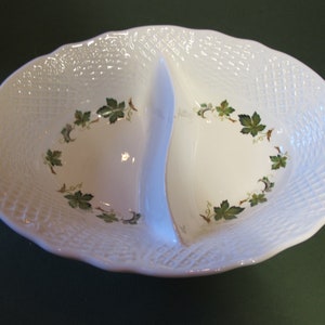 May include: White ceramic divided serving dish with a woven pattern and green leaf design.