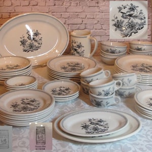 May include: A vintage set of white and black china dinnerware featuring a black and white bird design. The set includes plates, bowls, cups and saucers. The china is in excellent condition and would be a lovely addition to any home.