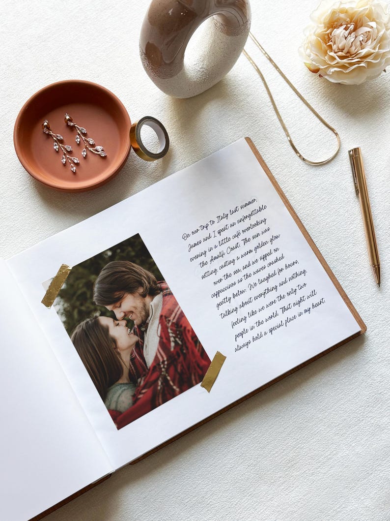 May include: An open scrapbook with a photo of a couple, accented with gold washi tape. A terracotta dish holds earrings. A gold pen, necklace, and decorative ring are also present. The page has handwritten text.
