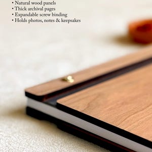 May include: A wooden journal with natural wood panels and thick archival pages. The journal features expandable screw binding and is designed to hold photos, notes, and keepsakes. The text "Crafted to Last a Lifetime" is at the top.
