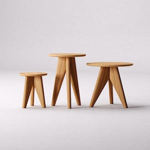 May include: Three wooden tables of different sizes with a round top and three legs. The tables are made of light brown wood and are arranged in a row from smallest to largest.