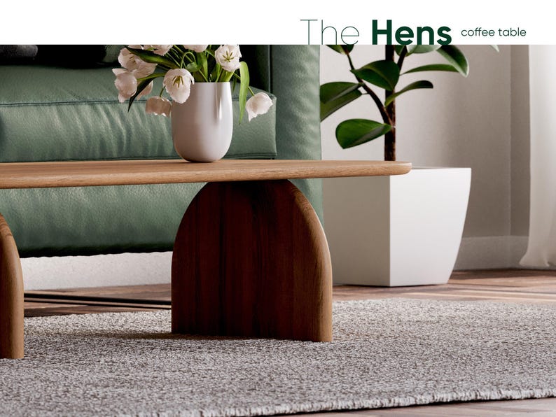 K&ouml;nnte beinhalten: Ein Holz-Couchtisch mit einem geschwungenen Sockel und einer hellen Holzoptik. Der Tisch steht auf einem grauen Teppich vor einem gr&uuml;nen Sofa.