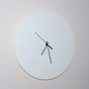May include: A white round clock with black hands on a white wall.