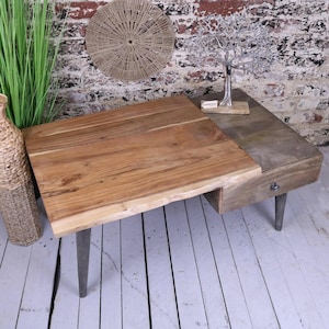 May include: A wooden coffee table with a live edge top and a drawer on the side. The table has black metal legs and a natural wood finish.