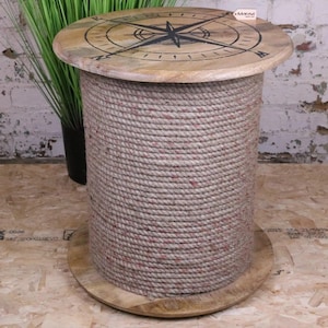 May include: A round side table with a nautical theme. The top is made of light-colored wood with a compass rose design. The base is a cylindrical form wrapped in thick, beige rope. The table is approximately 20 inches in diameter and 20 inches tall.