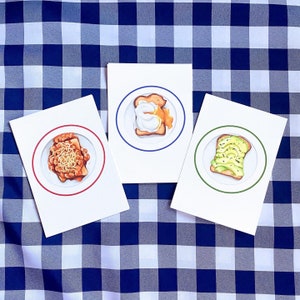 Trio di cartoline a tema brunch/colazione. Uova in camicia, fagioli al forno e toast con avocado
