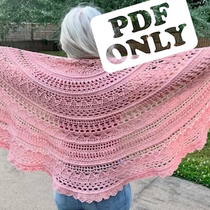 May include: A light pink crochet shawl featuring a semi-circular design with intricate lace patterns, multiple rows of openwork stitches, and a scalloped edge. A white rectangular label with the black text PDF ONLY is visible on the shawl.
