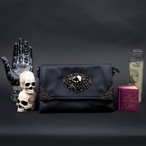 Alternative black bag by CHOK GothX styled with skulls, candles, and witchy prop decor.