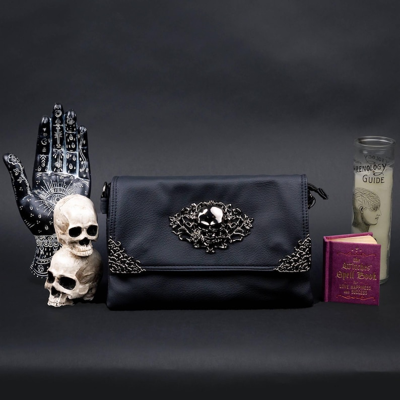 Alternative black bag by CHOK GothX styled with skulls, candles, and witchy prop decor.