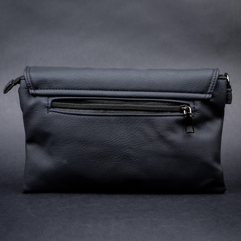 Rear view of the GOTHX black vegan leather bag with zip pocket for secure storage. Styled on a dark gothic background.
