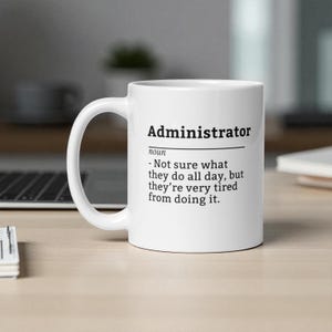 May include: White ceramic mug featuring the word "Administrator" in black, accompanied by a humorous definition. The definition states, "- Not sure what they do all day, but they're very tired from doing it."