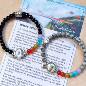 May include: Two beaded bracelets featuring black and grey stone beads, silver-toned spacers, and a sequence of small colorful beads. Each bracelet includes a circular charm with a dog photograph and silver letter beads spelling the name Lucca.