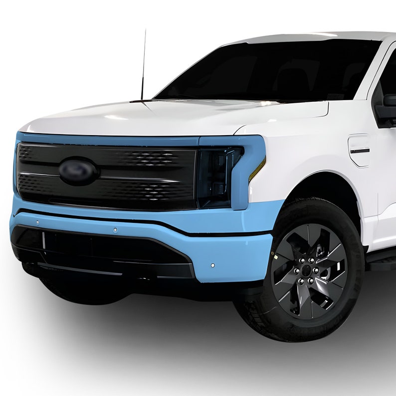 May include: A white pickup truck with a black grille and headlights. The front bumper is painted blue.