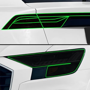 Könnte beinhalten: Nahaufnahme von zwei Rücklichtern eines Autos. Die Rücklichter sind schwarz und haben einen grünen Umriss. Die Rücklichter befinden sich an einem weißen Auto.