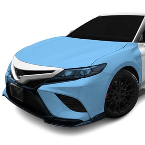 Pode incluir: Um carro azul claro com um pára-choques dianteiro preto e rodas pretas. O carro tem uma grelha prateada e faróis pretos.