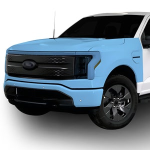 May include: A light blue pickup truck with a black grille and headlights. The truck has a black bumper and black wheels.
