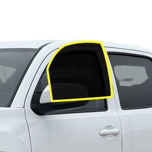 May include: A white pickup truck with a tinted window on the driver's side. The window is framed in black and has a yellow outline.