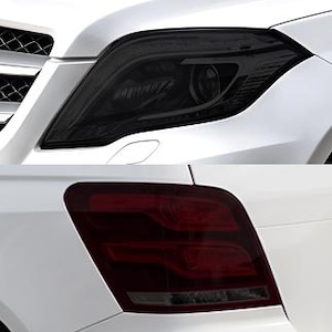 May include: A white vehicle featuring a dark tinted front headlight assembly with integrated projector lenses and a separate dark tinted rear taillight assembly with horizontal red light bars and a clear lower section on a white body panel.