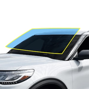 Op de afbeelding: Een witte SUV met een blauw en geel gemarkeerde voorruit. De voorruit is getint en de koplampen van het voertuig zijn zichtbaar. De afbeelding is een close-up van de voorkant van de auto.