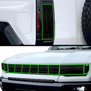 May include: A white pickup truck with blacked-out headlights and taillights. The headlights are divided into multiple sections.