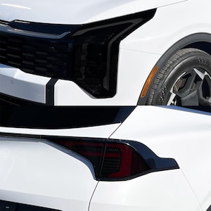 May include: Close-up of a white car with black detailing. The image shows the front headlight and rear taillight, both with a dark tint. The car's wheel is visible, with a black rim and a tyre.