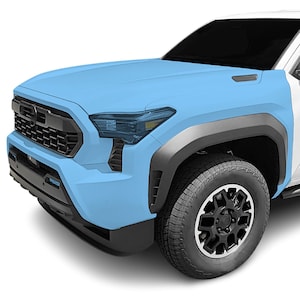 May include: Close-up of a light blue pickup truck with black wheels and a black front bumper. The truck has a black grille and headlights.