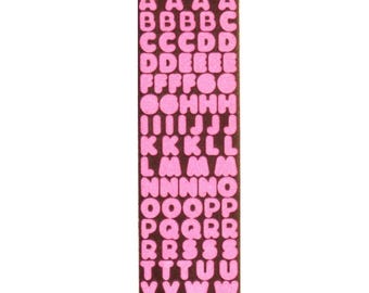 May include: A rectangular sheet of pink felt letters on a brown background. The letters are arranged in alphabetical order, with multiple instances of each letter. Ideal for crafting and personalization projects.