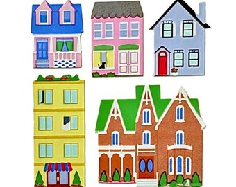 May include: A set of five flat house-shaped ornaments featuring a blue house with a pink porch, a pink house with a black cat, a light blue house with a red door, a yellow four-story building with a striped awning, and a brown house with a green roof.