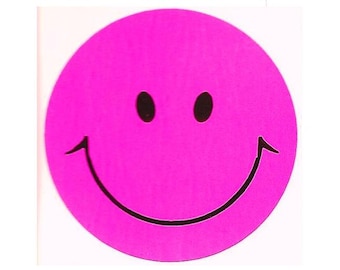 May include: A circular sticker featuring a vibrant hot pink background with a simple black graphic of a classic smiley face. The design consists of two solid black oval eyes and a wide, curved black line representing a smiling mouth.