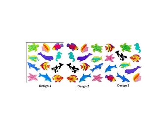 May include: A collection of colorful sea creature stickers arranged in three distinct groups labeled Design 1, Design 2, and Design 3. The stickers feature various marine animals including turtles, whales, dolphins, seahorses, starfish, and tropical fish.