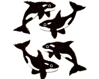 May include: Four individual orca whale appliques featuring a classic black and white color scheme. Each orca is depicted in a swimming pose with a distinct dorsal fin, tail fluke, and white eye patch, rendered in a textured, felt-like material.