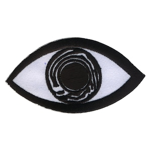 Könnte beinhalten: Gesticktes Augen-Patch mit schwarzem Umriss und weißem Innenraum. Die Pupille des Auges ist schwarz mit konzentrischen Kreisen. Zum Aufnähen auf Kleidung oder Accessoires.