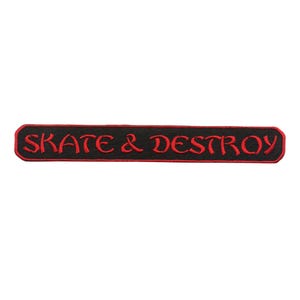 Könnte beinhalten: Schwarzer und roter gestickter Aufnäher mit dem Text "Skate & Destroy" in einer gotischen Schrift.
