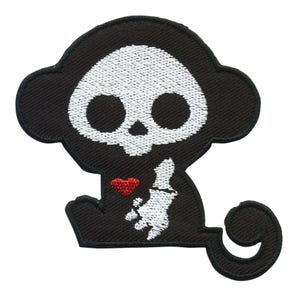 May include: Black embroidered iron-on patch of a cartoon monkey with a skull face holding a red heart.