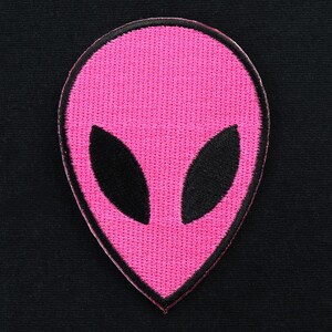 May include: Pink alien head embroidered patch with black eyes.