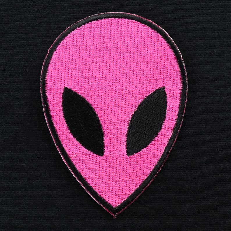 May include: Pink alien head embroidered patch with black eyes.