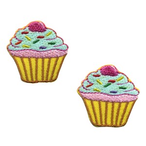 Può includere: Due toppe ricamate da stirare a forma di cupcake con glassa blu, glassa rosa e codette colorate.