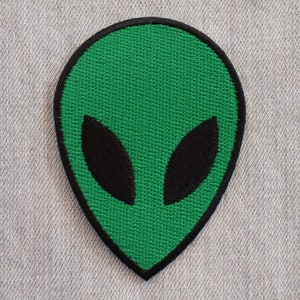 May include: Green alien head embroidered patch with black eyes.