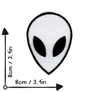 May include: White alien head embroidered patch with black eyes. The patch is 8cm wide and 8cm tall.