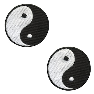 May include: Two embroidered patches featuring the Yin and Yang symbol. Each circular patch has a black background with a white, curved design. The white portion is embroidered with white thread, and the black portion is solid.