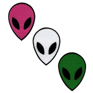 Könnte beinhalten: Drei Alien-Kopf-Patches in Pink, Weiß und Grün. Jeder Patch hat schwarze Augen und einen schwarzen Umriss.