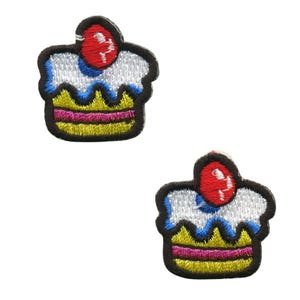 May include: Two embroidered iron-on patches of a cupcake with a red cherry on top. The cupcake is yellow with pink and white frosting and a blue swirl.