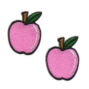 May include: Two pink embroidered iron-on patches shaped like apples with green leaves.