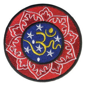Pode incluir: Etiqueta bordada vermelha com um círculo azul contendo um símbolo Om amarelo e estrelas brancas. O círculo é rodeado por uma flor de lótus vermelha com detalhes brancos.