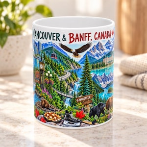 May include: A white ceramic mug featuring a colorful illustration of Vancouver and Banff, Canada. The design includes a bald eagle, a black bear, a beaver, a hockey skate, a bowl of snacks, mountains, a clock tower, and a sign pointing to Whistler.