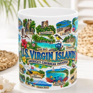 May include: A white ceramic mug featuring a colorful collage of U.S. Virgin Islands landmarks, including Blackbeard's Castle, Trunk Bay, and Buck Island Reef. The text reads U.S. VIRGIN ISLANDS and AMERICA'S CARIBBEAN PARADISE with tropical illustrations.