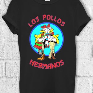 Peut inclure: T-shirt noir avec un motif de deux poulets de dessin animé portant des sombreros et le texte "Los Pollos Hermanos" dans une police de caractères stylisée.