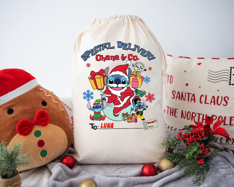 May include: A white canvas gift bag with a blue Stitch character from Lilo & Stitch wearing a Santa hat and holding a gift. The bag has the text "SPECIAL DELIVERY Ohana & Co" and "To: LUNA".